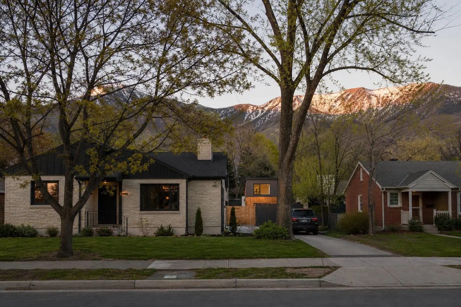 Established Salt Lake Valley street of modest homes with the Wasatch Range behind